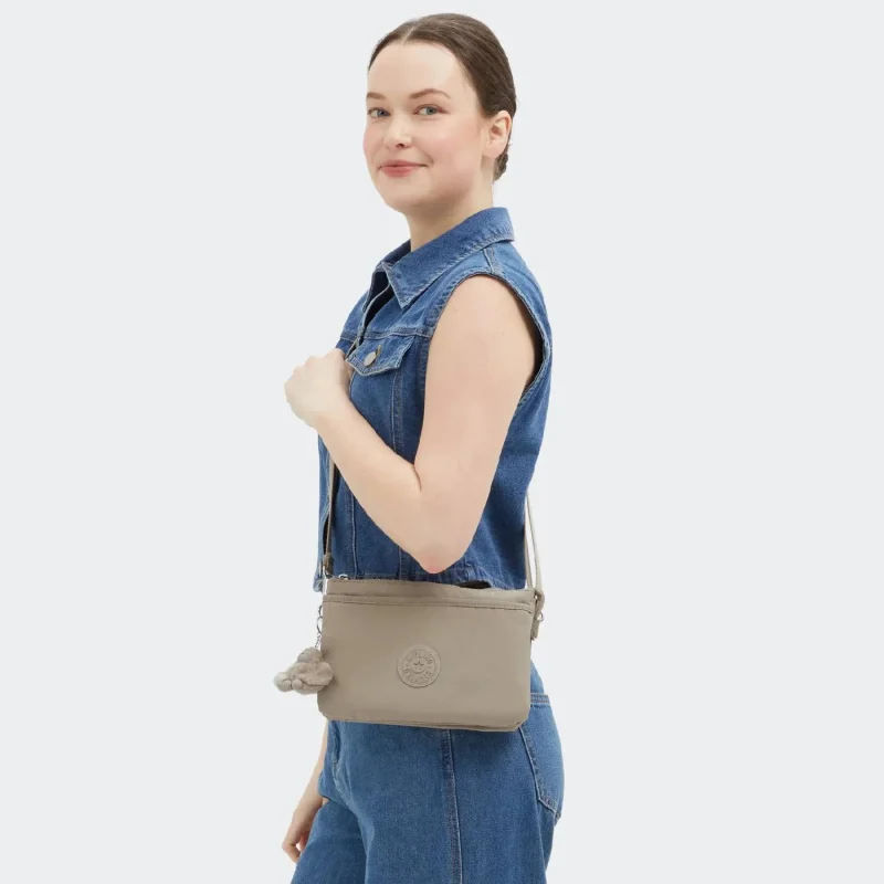 Petit Sac Bandoulière Kipling avec porte clé Riri KPKI75904PW1, couleur Soft Taupe, porté Petit Sac Bandoulière Kipling avec porte clé Riri KPKI75904PW1, couleur Soft Taupe, porté